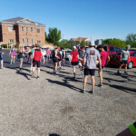 Pre-run warm-up exercises with Coach Courtney Duckworth. Photo by John Higgins