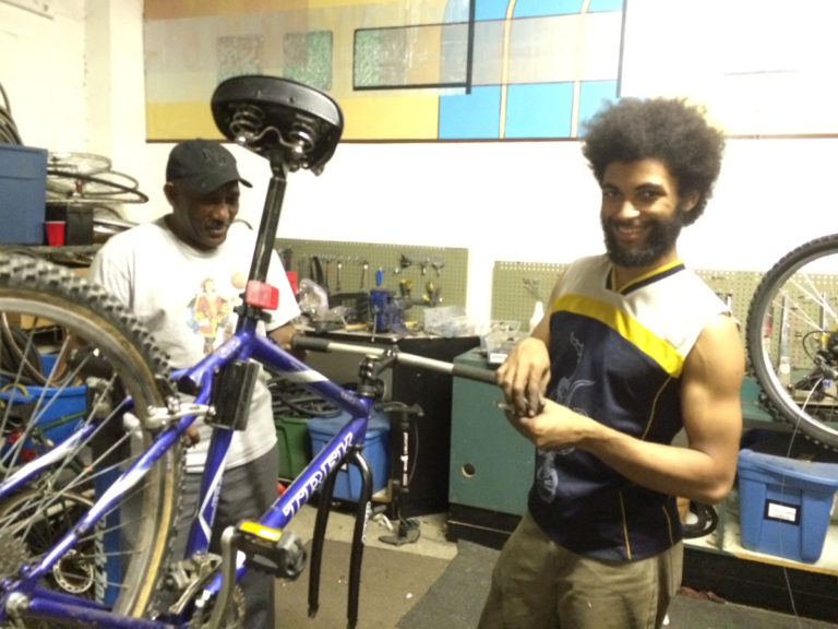 "African Americans were more than twice as likely as whites (38% vs 14%) to agree that their perception of bicyclists would improve if people on bikes represented a “broader cross section of Americans, such as women, youth and people of color” in their community." (from the League of American Bicyclists The New Majority, Pedaling Towards Equity Report). Here, two bicycle mechanics work at the Freewheel Community Bike Shop in Madison, Wisconsin. Photo by Dave Iltis